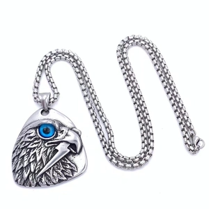 Gros plan d'un pendentif aigle argenté avec œil bleu et détails de plumes gravés