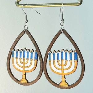 Hanukkah teardrop wooden earrings featuring a golden Menorah with blue candles on white background