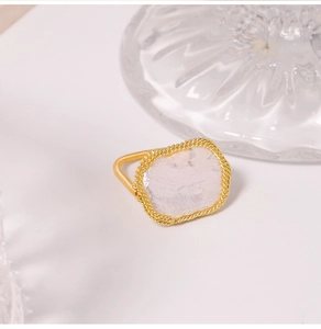 Detail shot of wrap-around gold ring with irregular translucent white baroque pearl