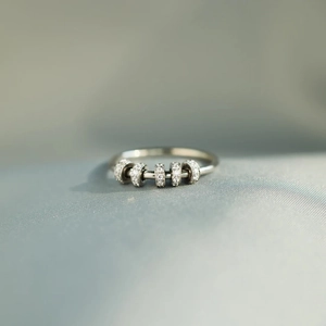 Macro detail of S925 sterling silver spinning fidget ring with five zircon beads
