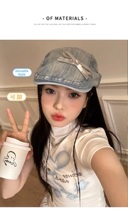 Detailed view of silver bow and pink gemstone on light blue denim beret for women