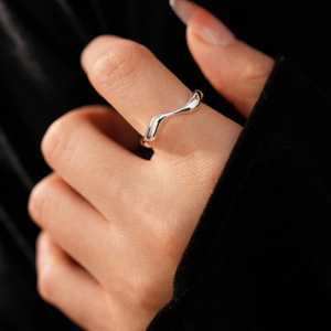 Close-up of wavy 18k gold plated irregular ring with polished silver finish on finger