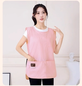 Detail of pink vest apron featuring three functional pockets and a stylish brand label