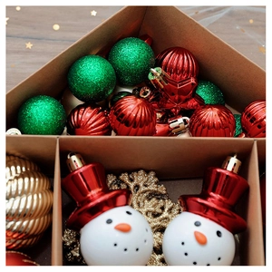 Detail of red stripe, green glitter balls and snowman ornaments in a gift box set