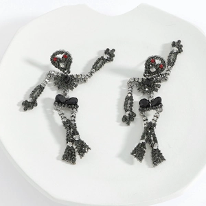 Macro shot of gunmetal skull earrings with grey rhinestones and red crystal eyes