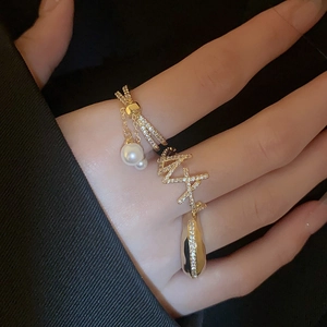Macro view of gold layered ring with pearls, zircons and wave letter decoration