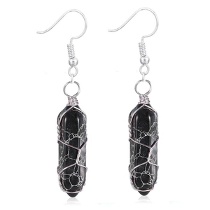 Detailed view of black hexagonal stone earrings with silver wire wrapped finish