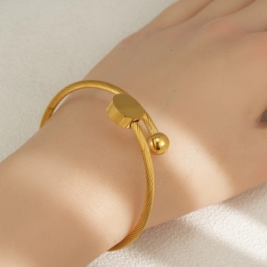 Minimalist gold stainless steel twisted rope bracelet featuring a flat disc and bead design