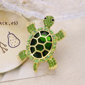 Broche tortue de mer dorée avec une grande gemme verte et des strass arc-en-ciel raffinés