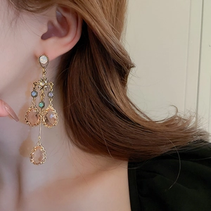 Detail of drop tassel earrings with champagne crystals and sparkling rhinestones on model