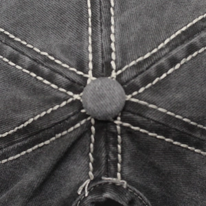 Détail de la couronne en coton lavé avec coutures contrastées et bouton sur le dessus
