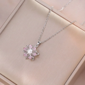 Collier orchidée argentée avec zircon rose et perle dans une boîte à bijoux