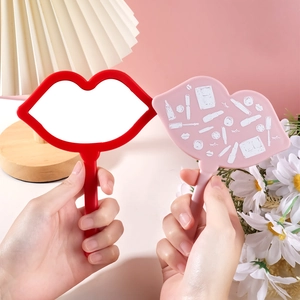 Detailed view of red and pink lip-shaped hand-held makeup mirrors with plastic handles
