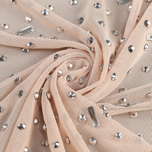 Detail of skin-tone mesh fabric with sparkling silver rhinestones and crystal embellishments