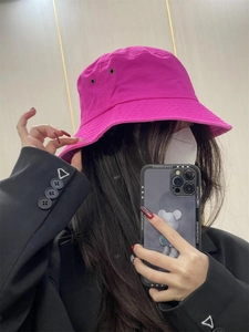 Detail view of a bright pink cotton sun hat with breathable eyelets on a female model
