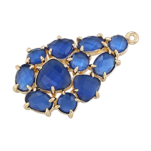 Elegant gold leaf pendant with blue gemstones shaped like grapes on a white backdrop