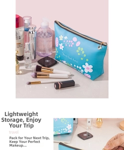 Detail of blue floral waterproof PU leather makeup bag with gold zipper and charms