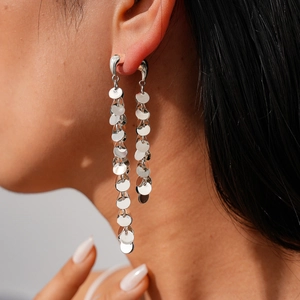 Boucles d'oreilles pendantes à paillettes argentées montrant la longueur sur le mannequin