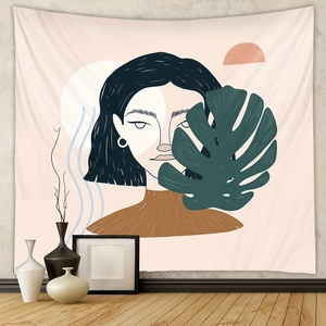 Detail of bohemian tapestry featuring abstract female portrait and monstera leaves art