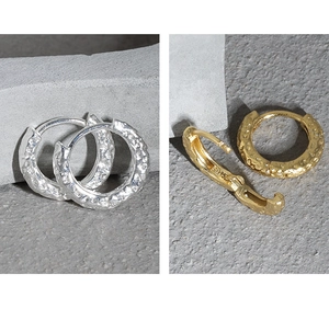 Macro detail of S925 sterling silver hoop earrings with textured hammered finish