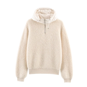 Détail d'un pull en maille crème avec capuche en nylon et poignets en bord-côte