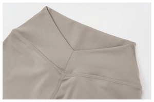 Detail des hoch taillierten V-Kreuz-Bunds der taupefarbenen Yoga-Shorts mit Flachnähten