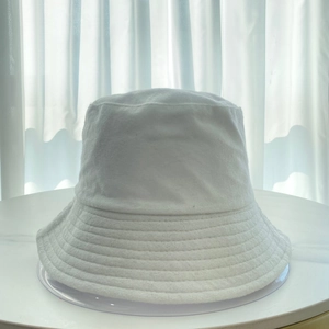 Close-up of white terry cloth fabric texture on a minimalist bucket hat surface