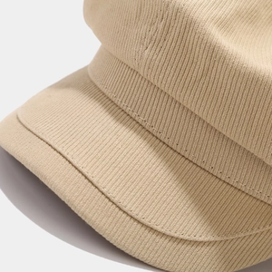 Macro shot of khaki corduroy newsboy cap showing texture and fine stitching detail