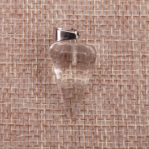 Macro shot of a faceted clear crystal pendulum pendant resting on a rustic burlap texture