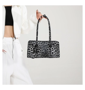 Detail of leopard print handbag with sleek silver accents and a heart-shaped charm