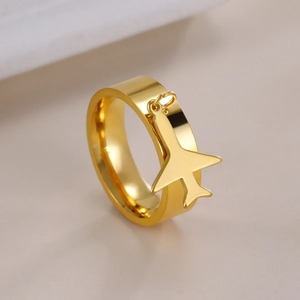 Macro shot of gold stainless steel ring featuring a polished small airplane pendant charm