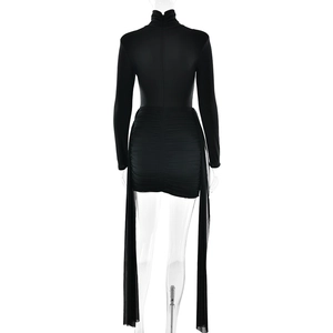 Détail d'une robe noire à manches longues avec volants latéraux en mousseline sur fond blanc