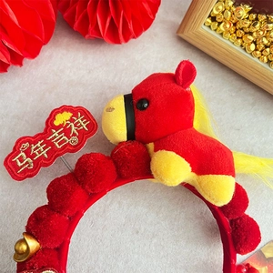 Detail of red plush headband with horse doll, golden ingots and lucky embroidery