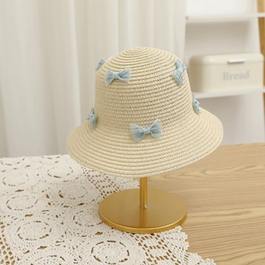 Detailed straw hat weaving with light blue lace bow on a decorative display stand
