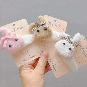 Detailed close-up of cute plush bunny hair clips in pink brown and white with bows