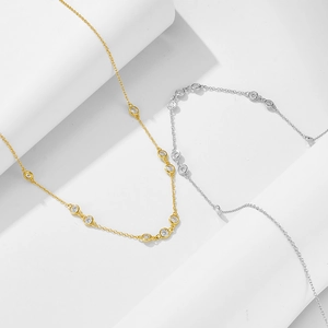 Detail of 925 silver gold and silver necklaces with round bezel-set sparkling crystals
