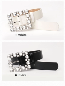 Close-up of white and black leather belts featuring crystal-encrusted square buckles