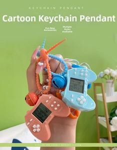 Detail view of retro mini game console keychain with pink silicone strap and small bell