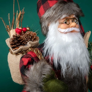 Classic Santa Claus doll in red plaid outfit with a burlap gift sack on green background