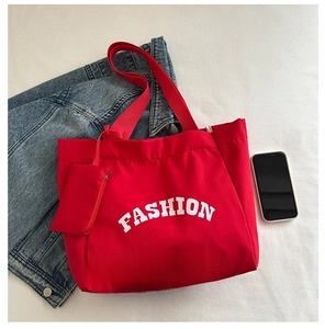Red canvas tote bag with fashion print and matching pouch shown next to a smartphone