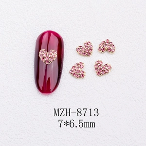 Detailed macro of 7x6.5mm gold and pink heart nail art charms with model MZH-8713