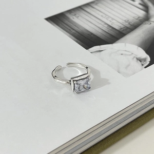 Detail of 925 silver open ring with rectangle zircon and textured band on book