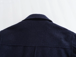 Détail d'une veste en tweed bleu marine montrant des coutures de qualité sur le col