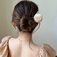 Elegante pinza per capelli a rosa in tessuto crema mostrata su un sofisticato raccolto