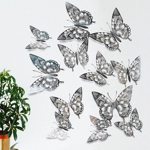 Detail of silver metallic hollow-out butterfly wall stickers on a clean white wall