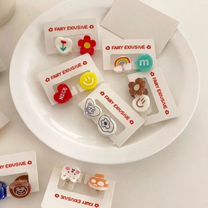 Detail view of colorful cartoon stud earrings set including rainbow and bear patterns