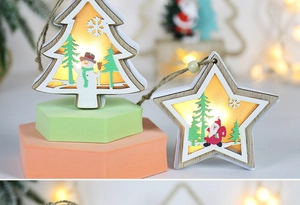 Detail of wooden LED Christmas ornaments with tree and star shapes in warm glow