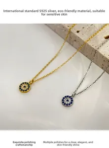 Detail of S925 sterling silver evil eye pendants in gold and silver with blue stones