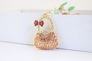 Macro shot of a golden handbag pendant adorned with sparkling pink and white rhinestones