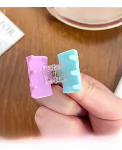 Detail of candy color acrylic hair claw clip with purple and teal contrast and metal spring